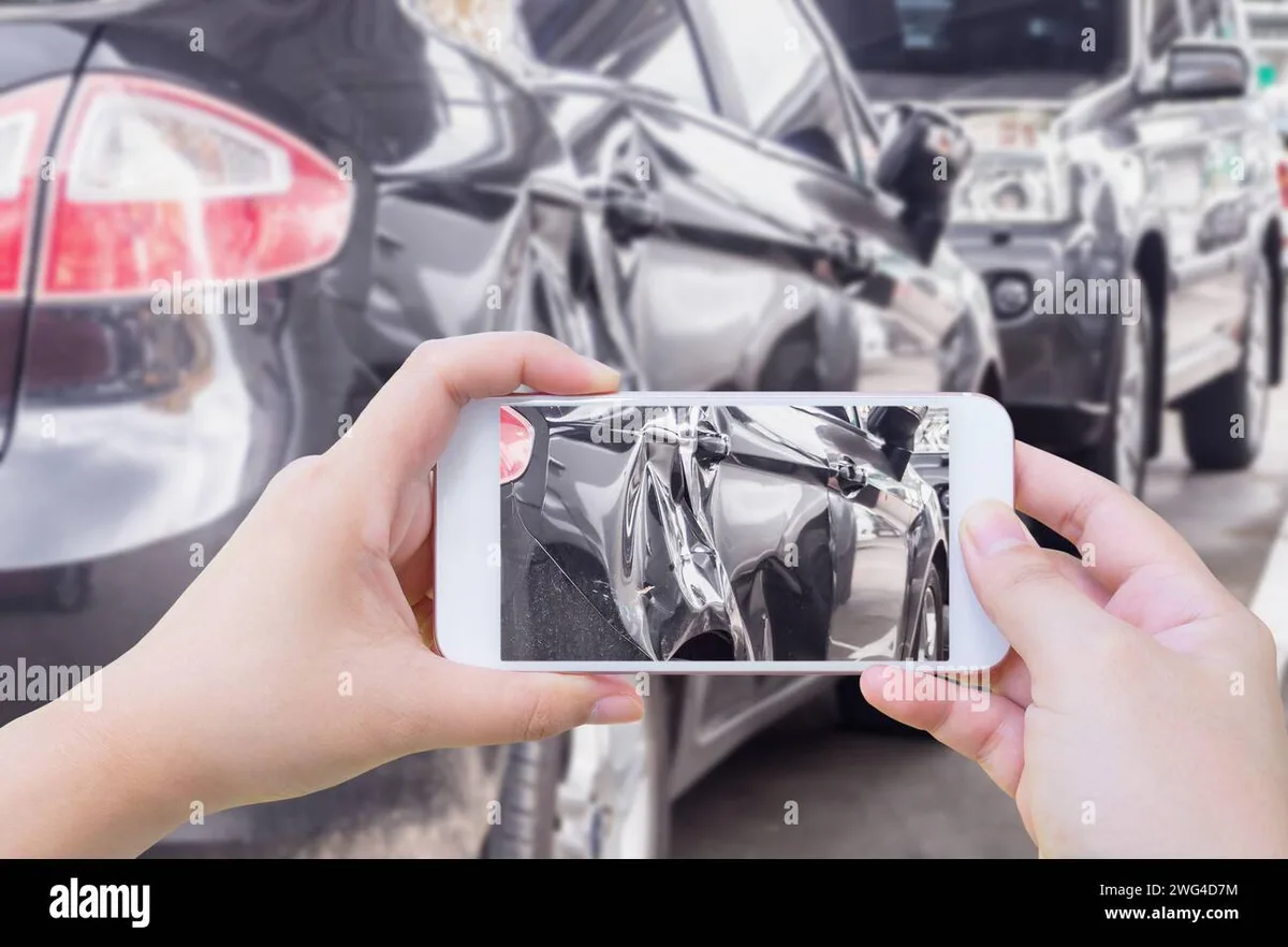 driver documenting accident scene with smartphone