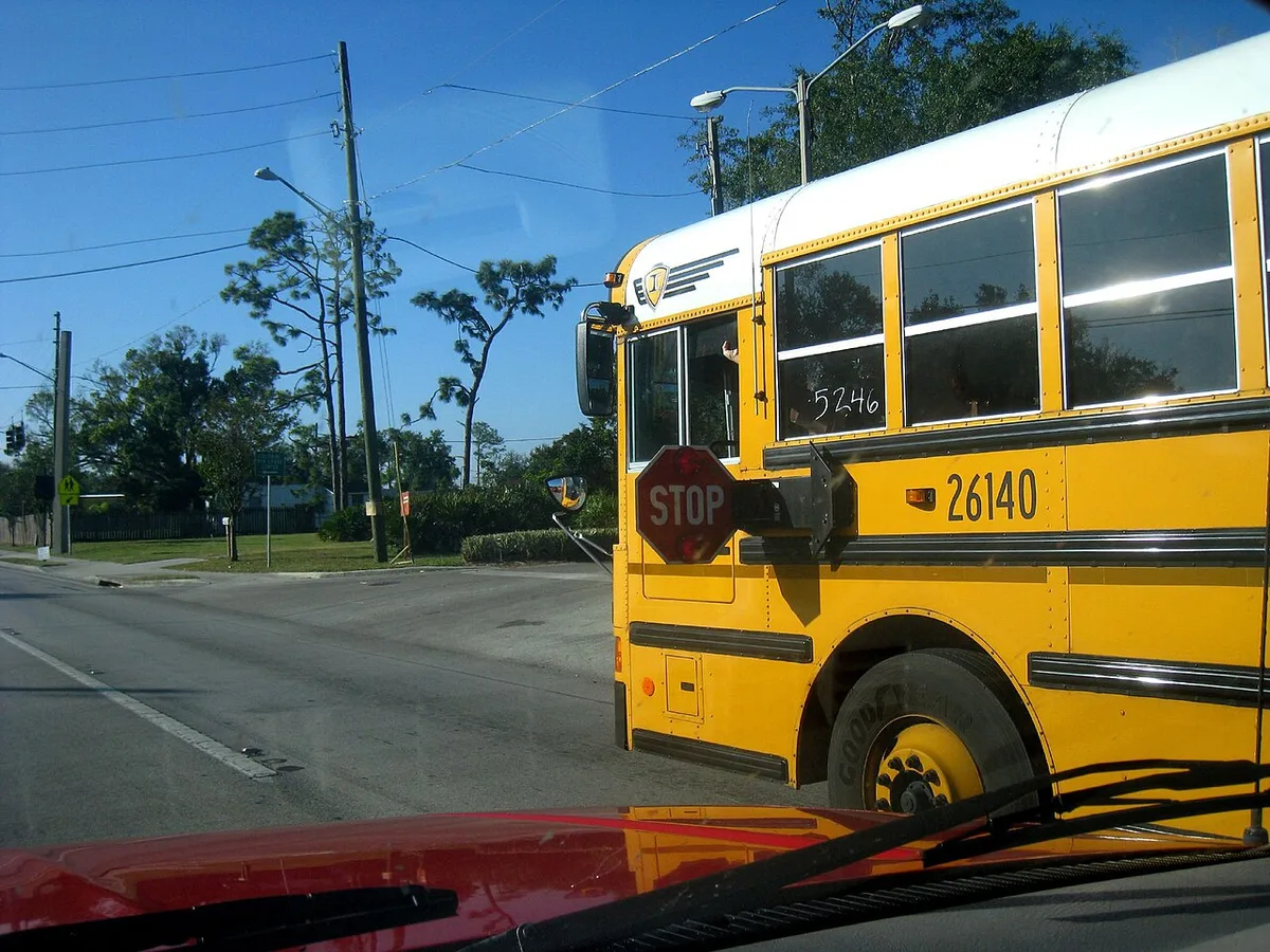 School bus with stop arm and flashing red lights