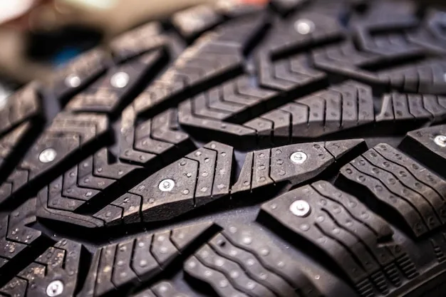 studded snow tire on icy road close up