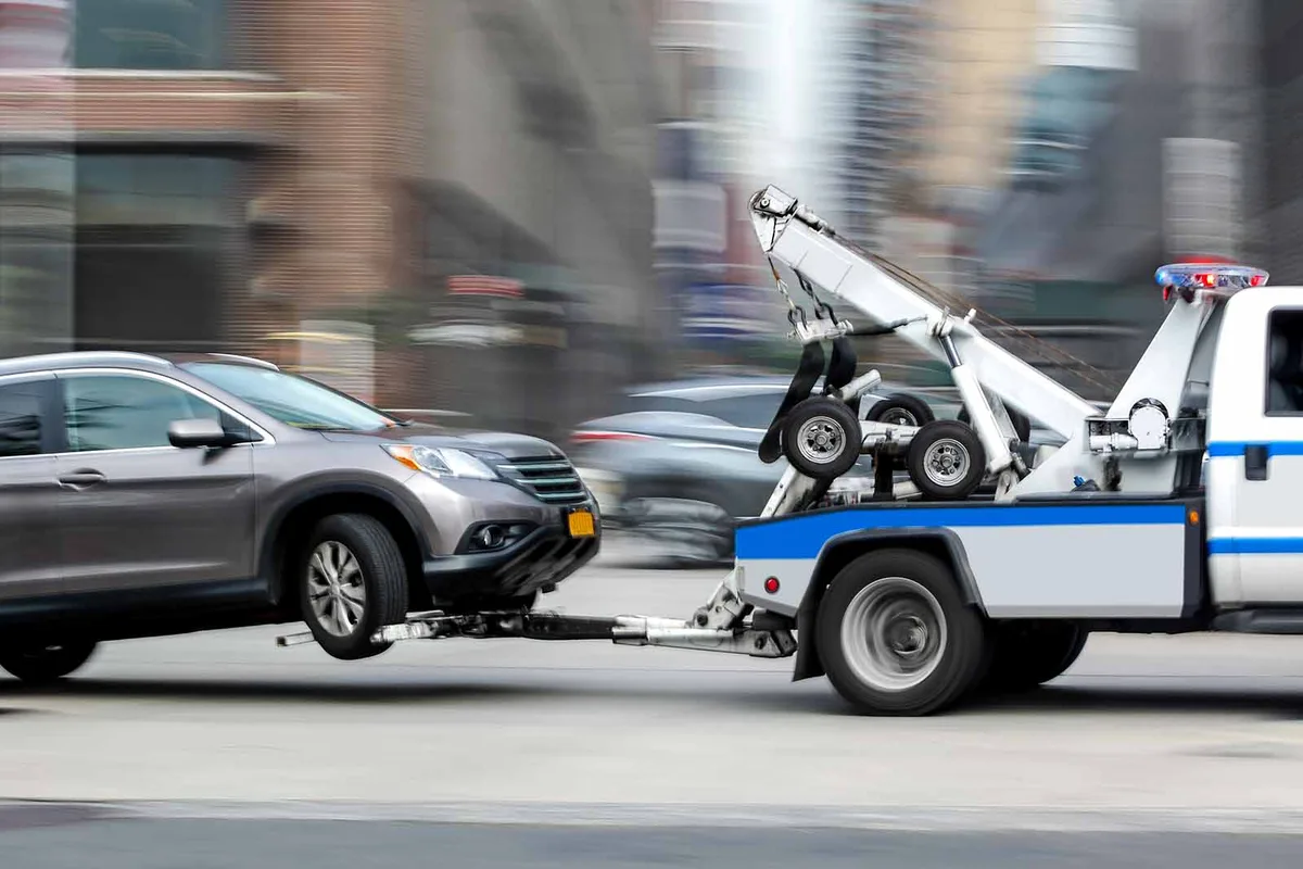 tow truck lifting abandoned car