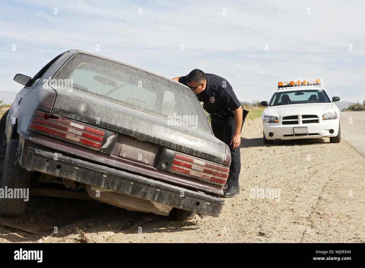 Connecticut police officer inspecting abandoned vehicle