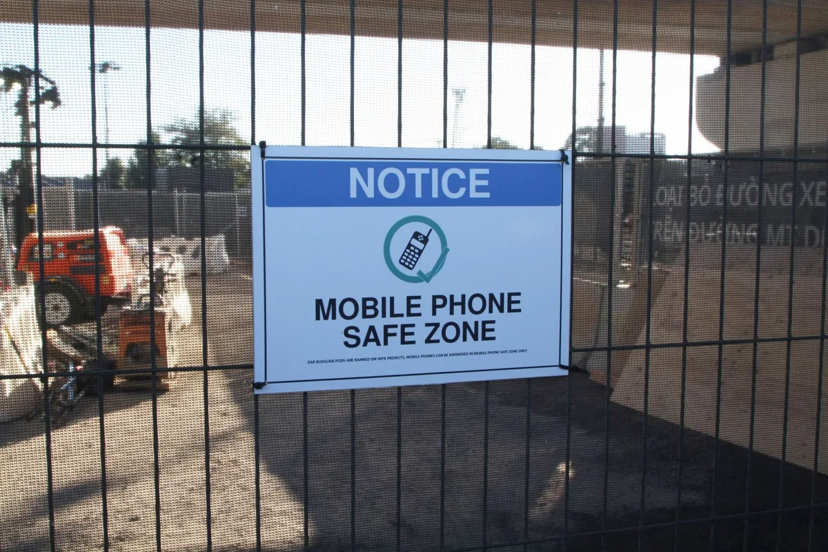 Construction zone warning sign with phone restriction