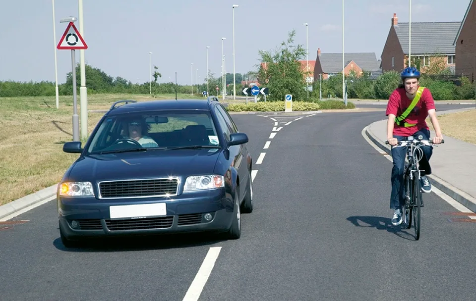 driver overtaking cyclist on rural road