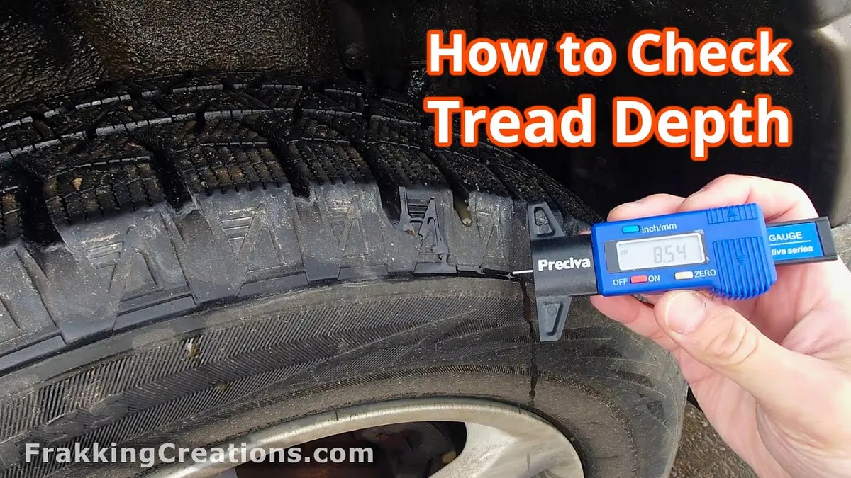 Mechanic checking tire tread depth with gauge