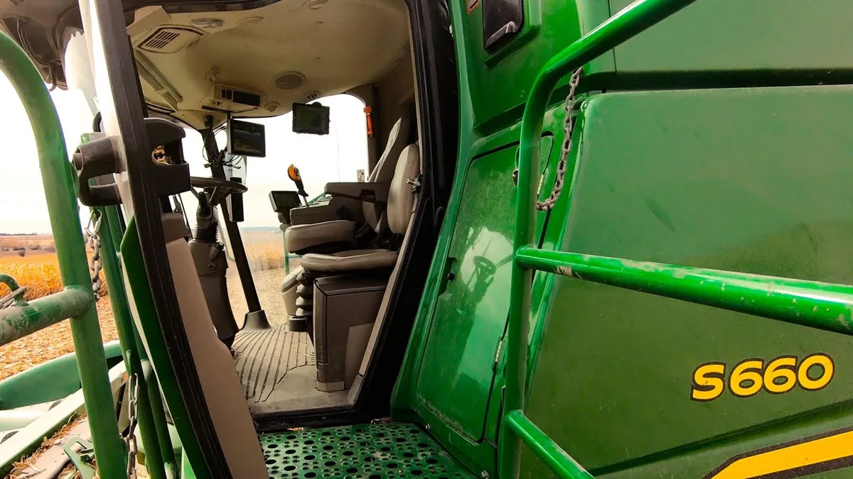 farmer driving combine harvester